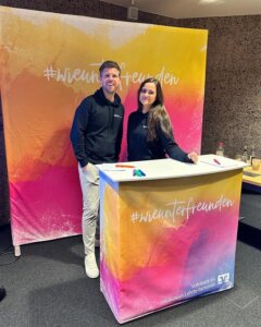 Eine Frau und ein Mann stehen hinter einer Messetheke