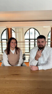 Ein Mann und eine Frau sitzen nebeneinander am Tisch.